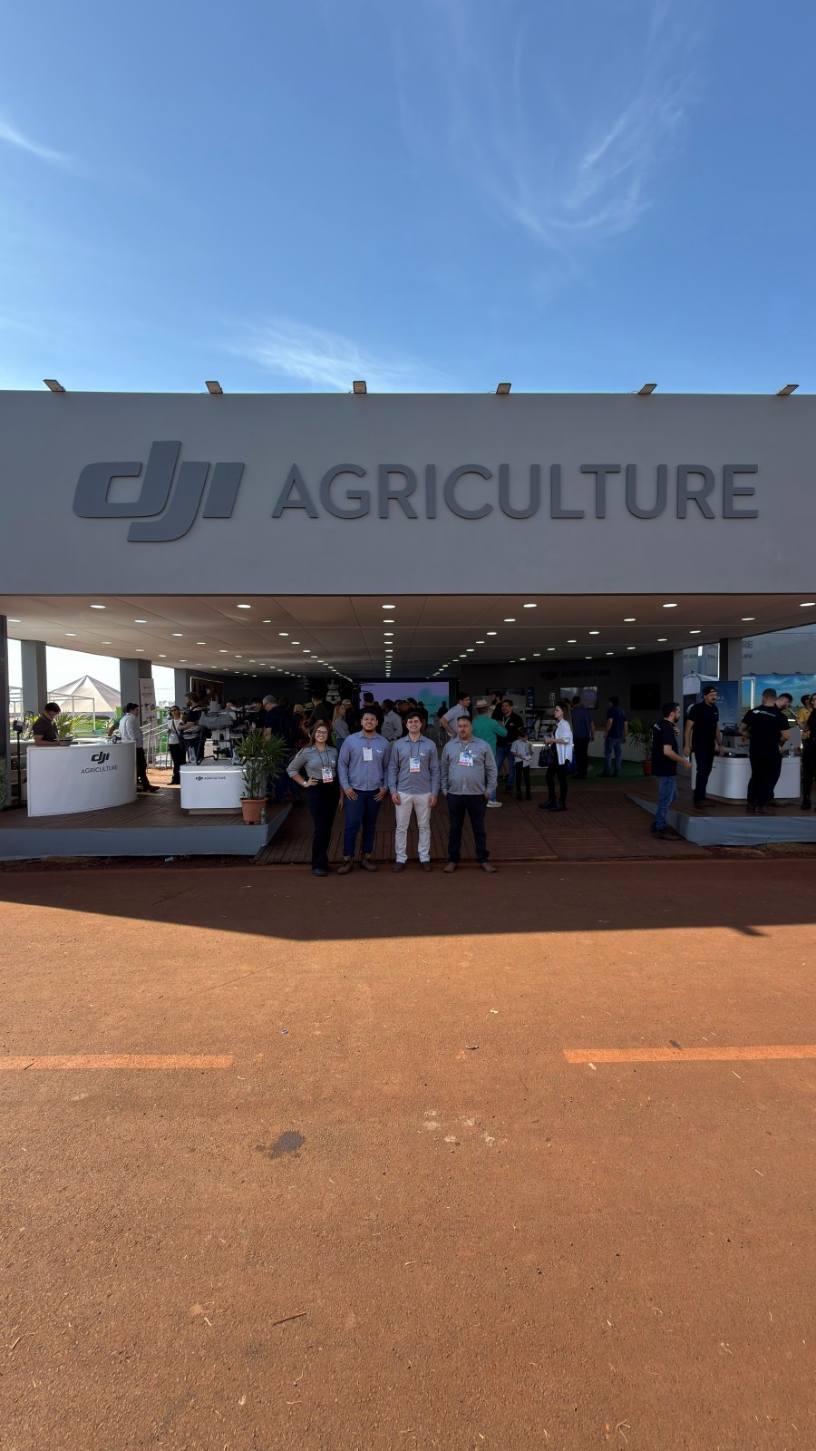 Equipe Kavita Drones na entrada do estande DJI Agriculture em feira agrícola